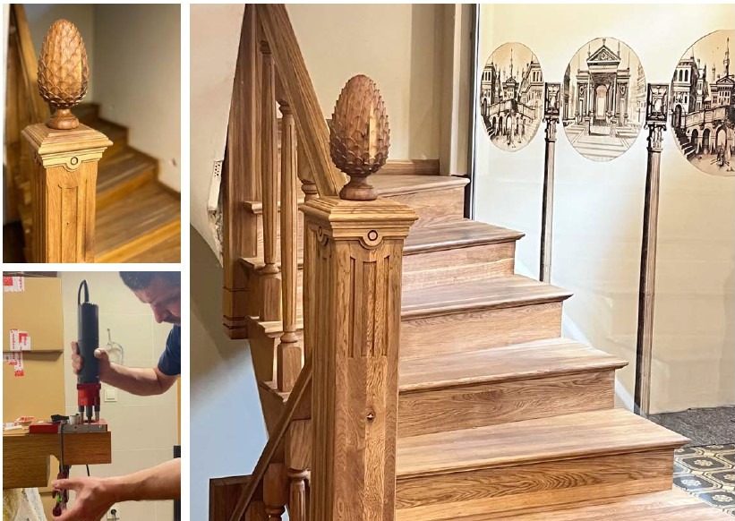 Drewniane schody z ozdobnymi słupkami i poręczą, zakończone rzeźbionymi elementami dekoracyjnymi. W tle widoczne rysunki architektoniczne na ścianie i etap obróbki drewna.