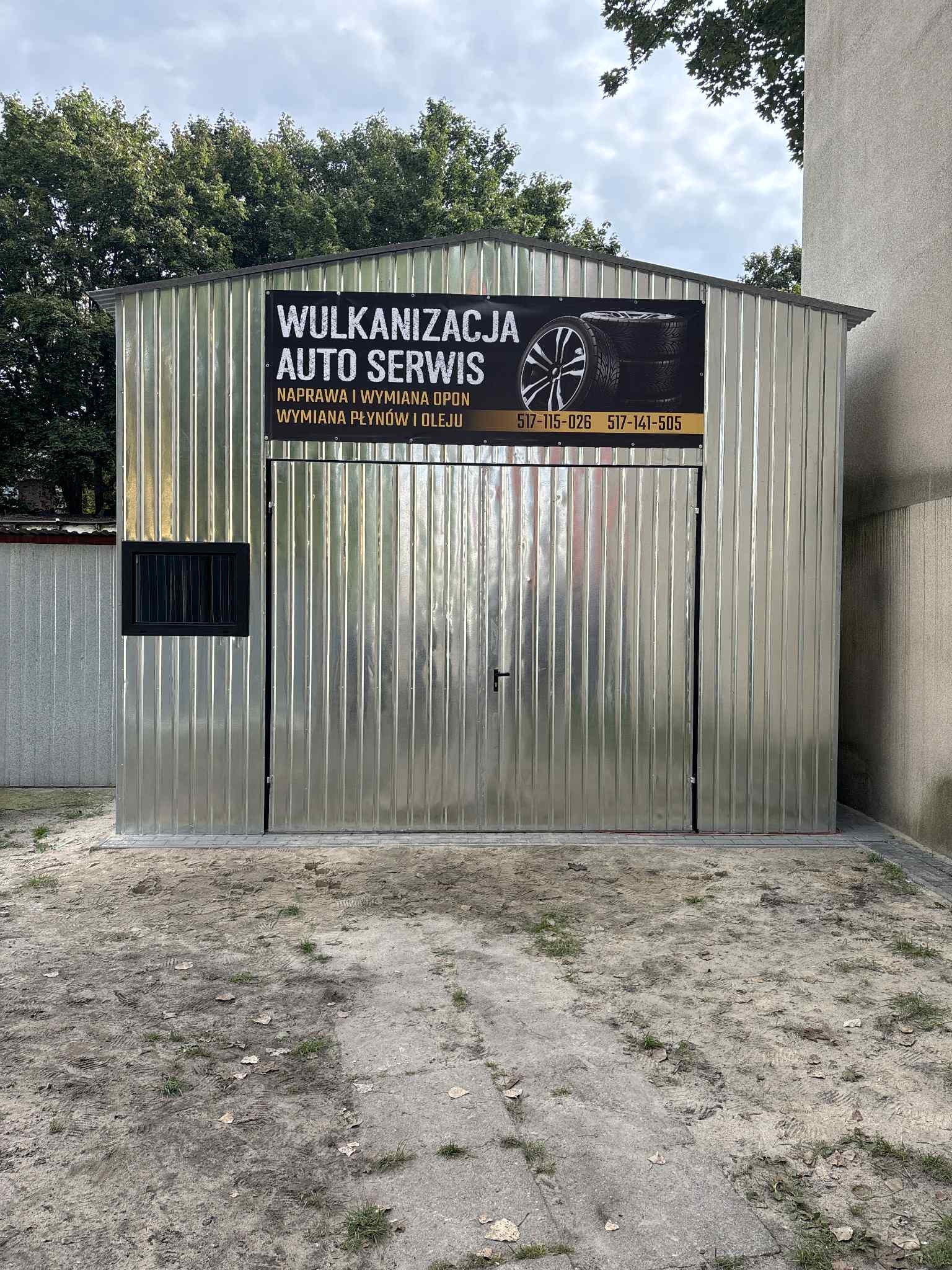 Blaszany garaż z szyldem 'Wulkanizacja Auto Serwis' oferujący naprawę i wymianę opon oraz wymianę płynów i oleju. Widoczne numery telefonów.
