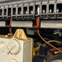 KRZYSZTOF GIDZIELA GiMedia - Wnętrze pieca gazowego z widocznymi elementami palnika, dyszami i pompą obiegową, ukazujące skomplikowaną konstrukcję urządzenia.