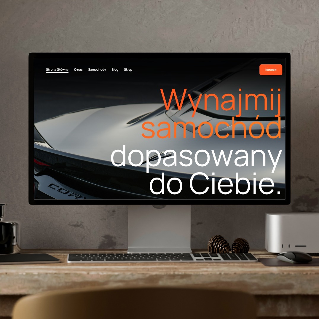 Ekran komputera prezentuje stronę internetową z ofertą wynajmu samochodu. Na ekranie widoczny fragment auta i hasło: 'Wynajmij samochód dopasowany do Ciebie.'