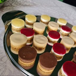 S-tech Solutions Ewelina Sikora - Elegancka taca z mini serniczkami o różnych smakach: cytrynowym, karmelowym, wiśniowym i czekoladowym, idealne na wykwintny catering.