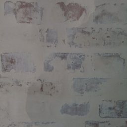 House-Serwis Ireneusz Korzeniewski - Ściana z imitacją cegły po szpachlowaniu, przygotowana do malowania. Widoczne ślady szpachli i niedokładności w strukturze. Delikatne nierówności podkreślają rustykalny charakter.