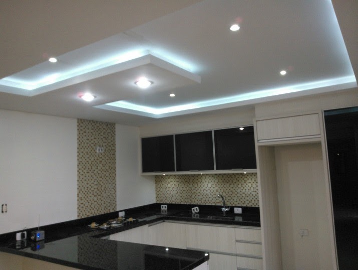 Nowoczesna kuchnia z oświetleniem LED podsufitowym i czarnym blatem. Mozaika na ścianie dodaje unikalnego charakteru wnętrzu.