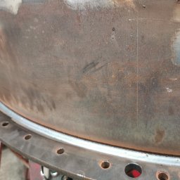 KB Krzysztof Bram - Spoina obwodowa na elemencie konstrukcji stalowej z otworami, wykonana w Bolesławcu. Widoczne ślady obróbki i patyna na powierzchni metalu.