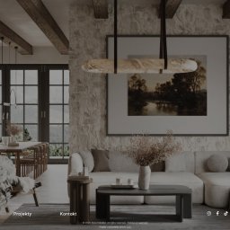 EZ Coding Emil Zygas - Strona www Alicji Kobiałki z widokiem na salon: sofa, stół, krzesła, okna. Minimalistyczny design, ciepłe barwy, kamienna ściana, obraz i drewniane belki stropowe.