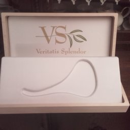 TRANSI P.U.H. - Otwarta, jasna, drewniana szkatułka z logo 'VS Veritatis Splendor' i wyprofilowanym wnętrzem na biżuterię, ustawiona na drewnianej powierzchni.