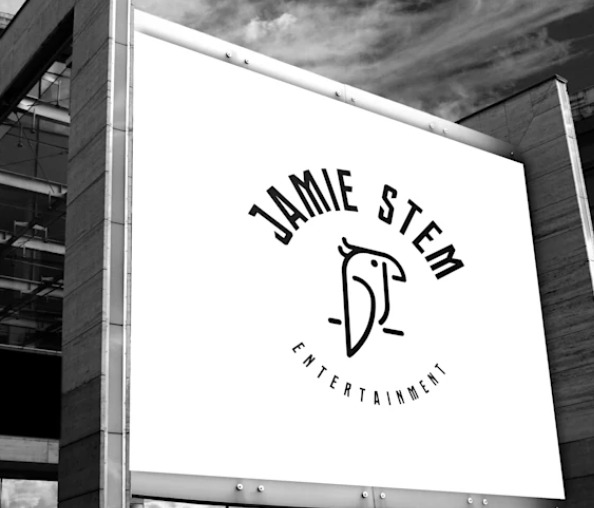 Czarno-białe zdjęcie billboardu z logo firmy Jamie Stem Entertainment, przedstawiające stylizowaną sowę i napis na tle nowoczesnego budynku.