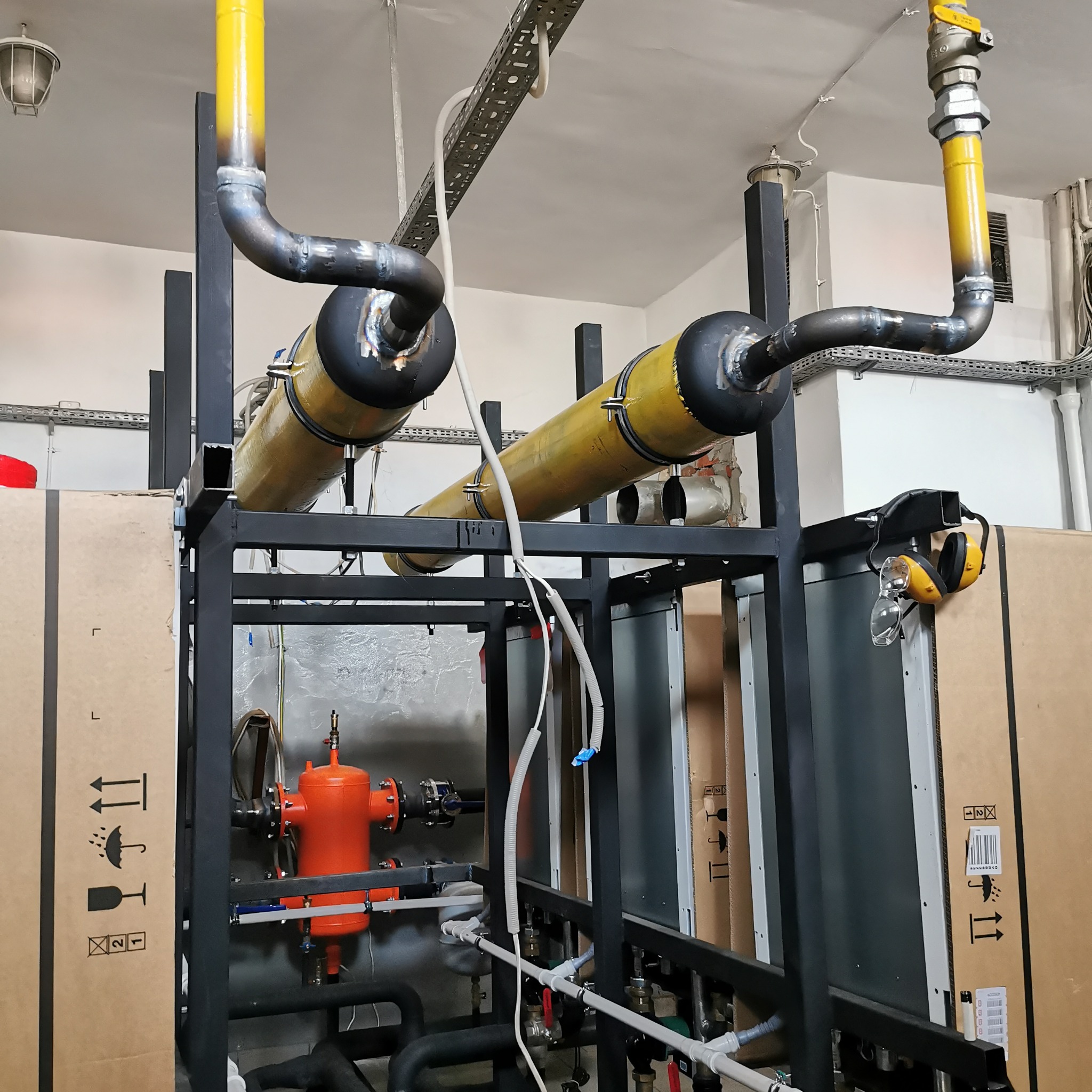 Kompleksowa instalacja gazowa w Niemcach: żółte rury, czarna konstrukcja wsporcza, czerwony filtr. Widoczne spawane łączenia i elementy bezpieczeństwa.