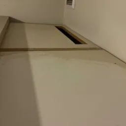 Zabrudzona powierzchnia szafki z widocznymi śladami po zalaniu i pleśni, wnętrze szafki z otworem wentylacyjnym, blaty wymagające gruntownego oczyszczenia.