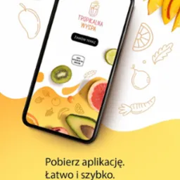 Smartfon z aplikacją 'Tropikalna Wyspa' na tle owoców. Grafika w odcieniach żółci prezentuje świeże owoce i zaprasza do pobrania aplikacji.