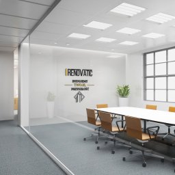 MAKX Projektowanie Graficzne - Nowoczesne biuro z przeszkloną ścianą, białe ściany i sufit, duży stół konferencyjny z krzesłami. Na ścianie logo firmy 'I Renovatic' z hasłem 'Budujemy Twoją Przyszłość'.