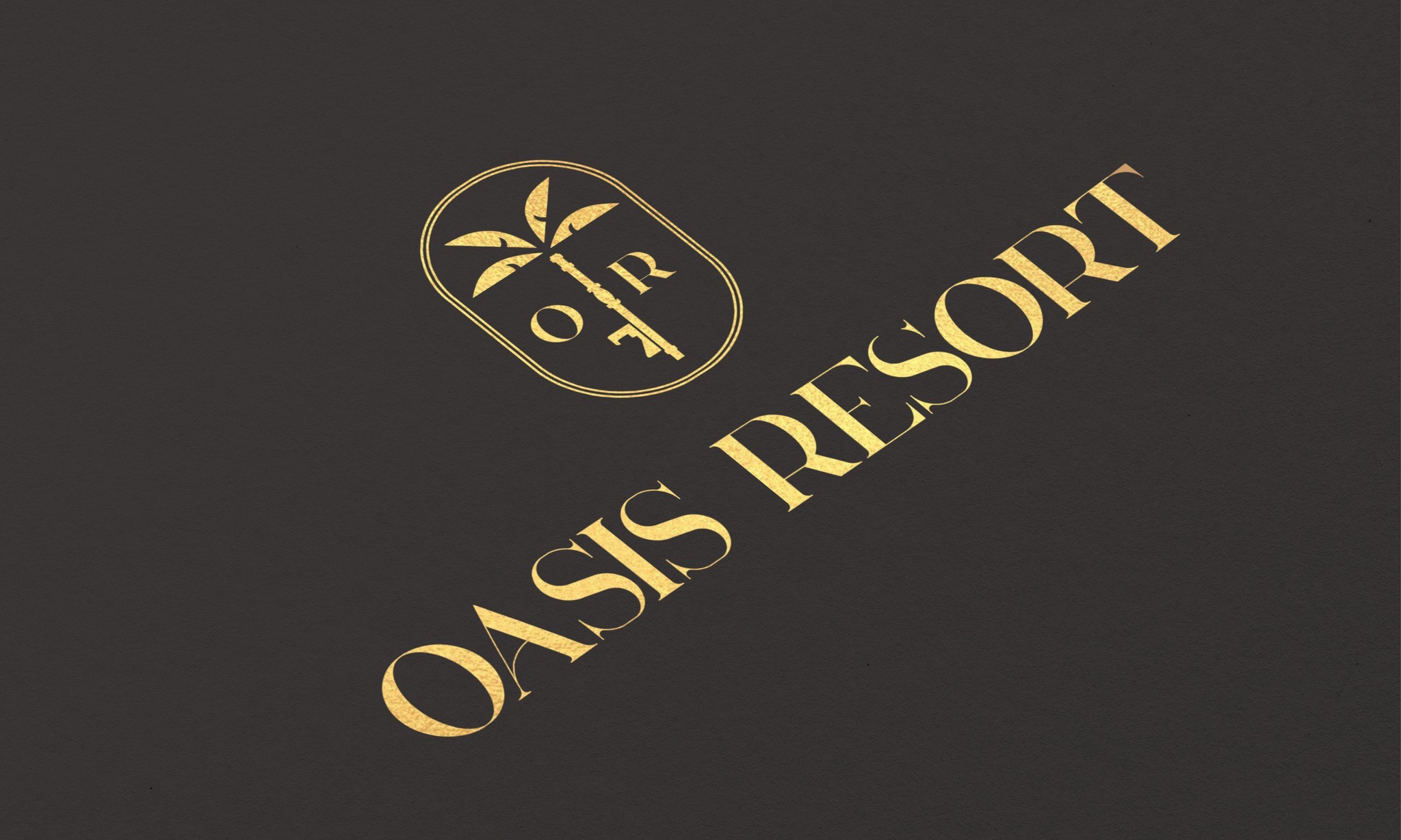Złote logo 'Oasis Resort' z palmą w owalu, ukośnie na ciemnoszarym tle. Elegancki font, minimalistyczny design, sugerujący luksusowy charakter miejsca.