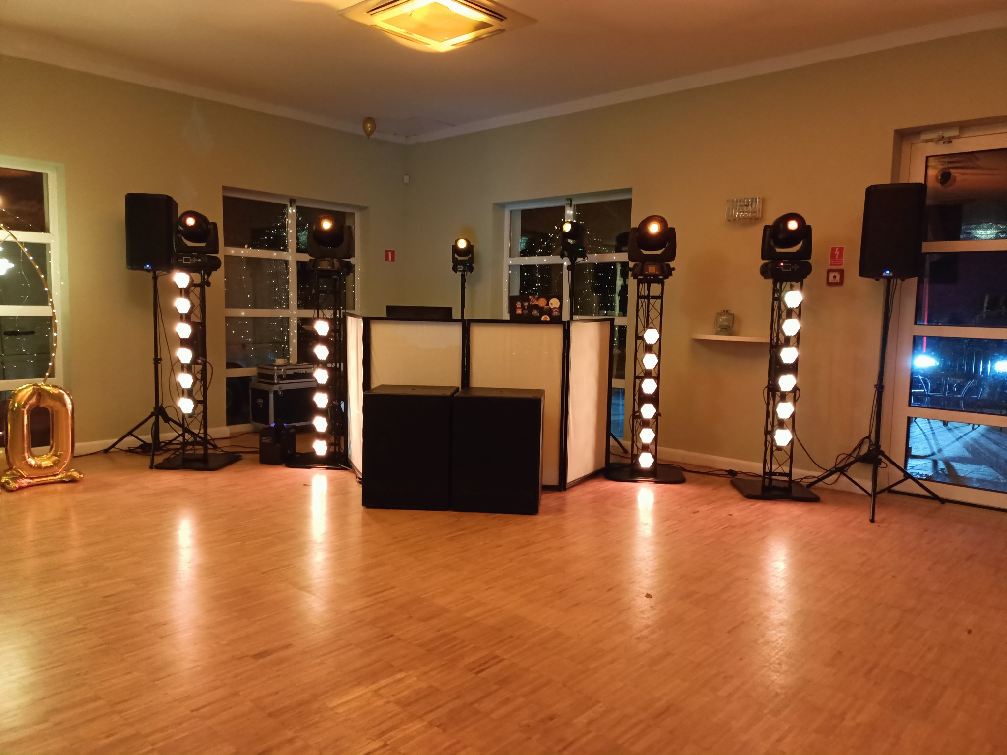 Profesjonalne nagłośnienie i oświetlenie sceniczne we Wrocławiu. Kompletny zestaw DJ-ski z kolumnami, reflektorami i dekoracyjnym oświetleniem na parkiecie.