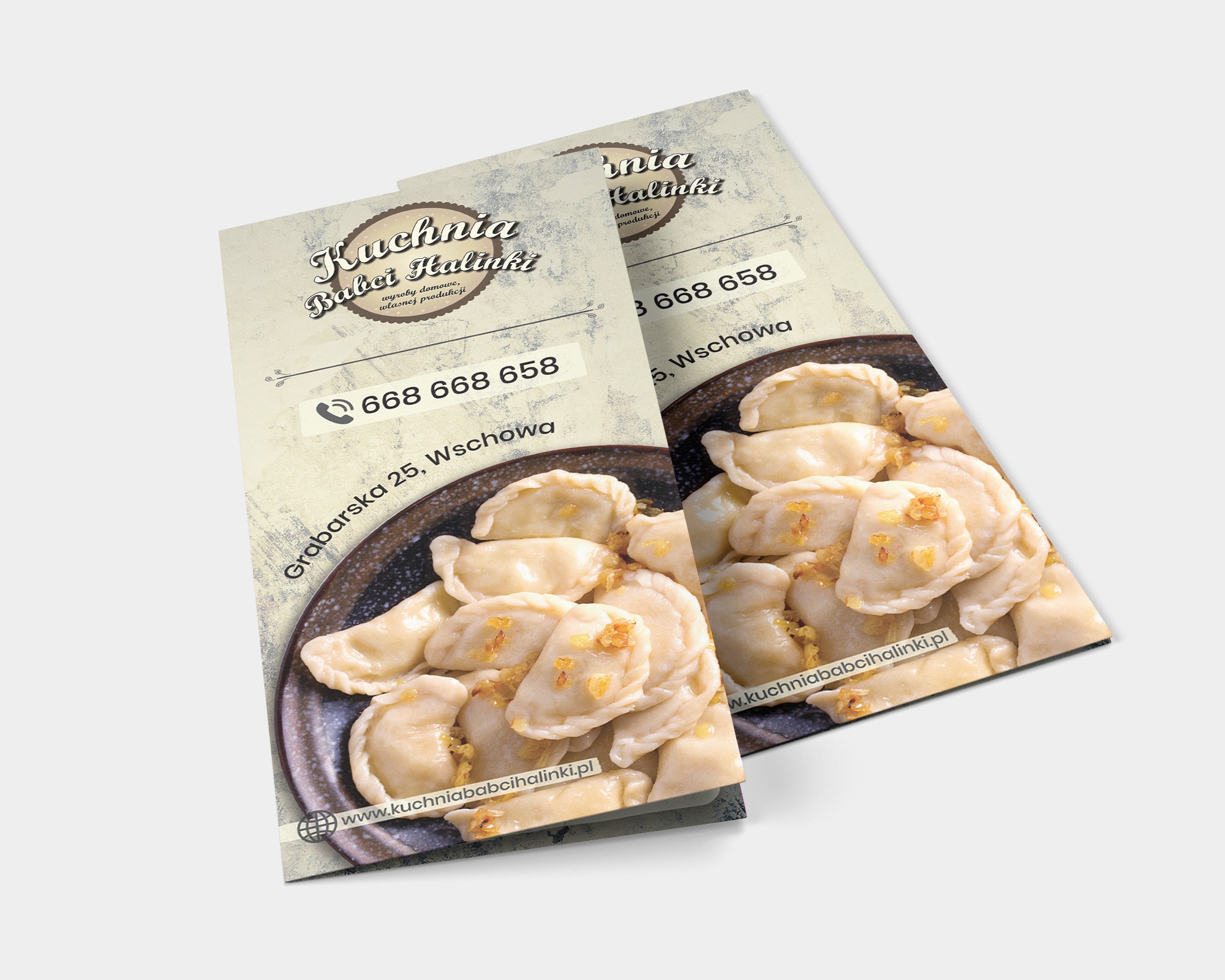 Dwa ulotki restauracji 'Kuchnia Babci Halinki' z domowymi pierogami, numerem telefonu i adresem na beżowym tle z teksturą. Ulotki leżą ukośnie na białym tle.