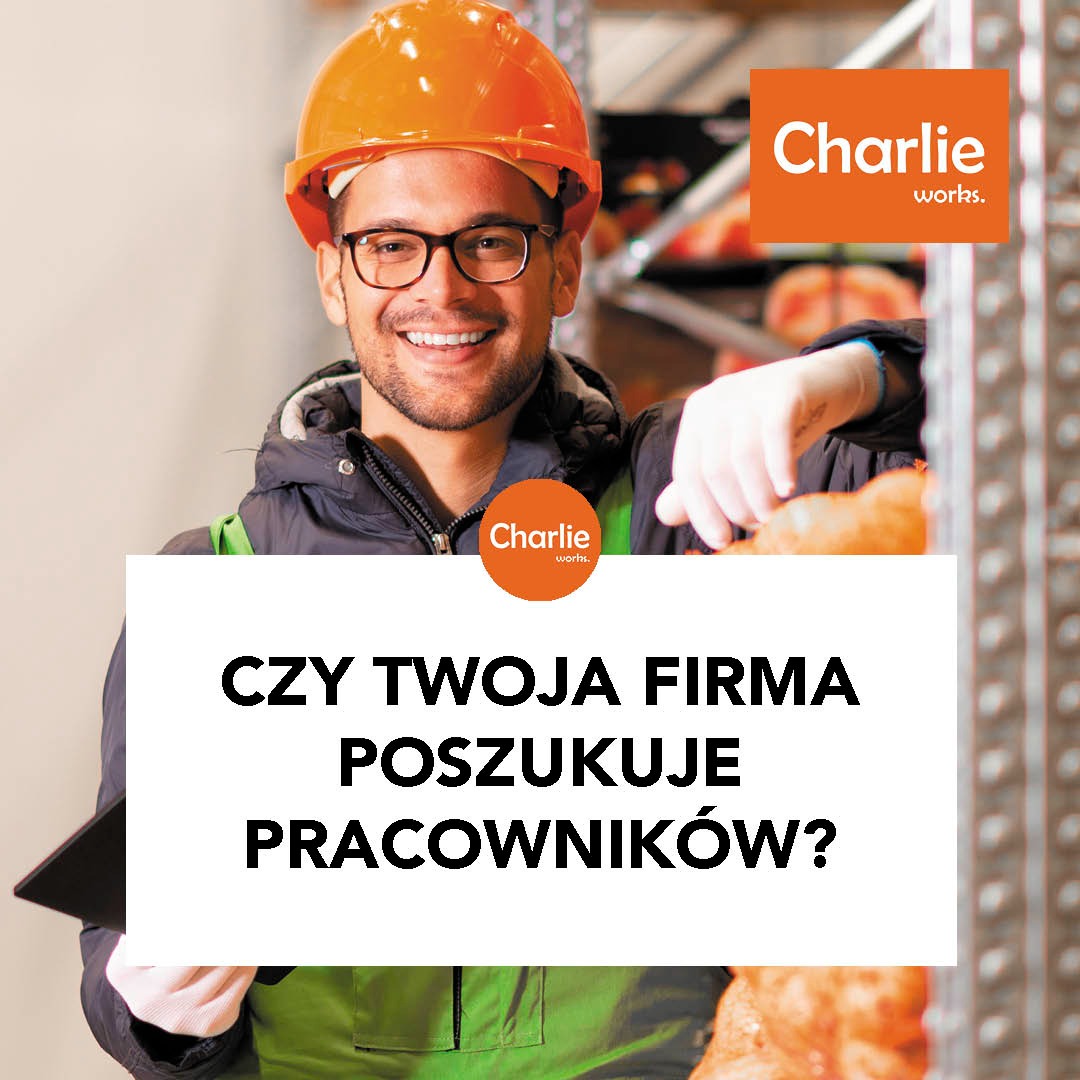 Uśmiechnięty mężczyzna w kasku BHP, z okularami, prezentuje ofertę outsourcingu. W tle regał magazynowy. Reklama firmy z logo Charlie works.