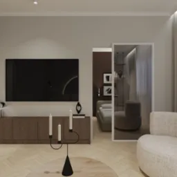 Nowoczesny salon z parkietem w jodełkę, beżową sofą i telewizorem na tle. Widok na sypialnię przez przeszklone drzwi. Minimalistyczny wystrój i ciepła kolorystyka.