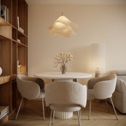 Architektura Wnętrz Aleksandra Łabuda - Jasne wnętrze jadalni: okrągły stół z kwiatami, trzy krzesła z tapicerką boucle, lampa w kształcie kwiatu i regał z książkami. Minimalistyczny design.