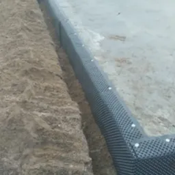 Fundamenty z izolacją pionową w wykopie. Widoczna folia kubełkowa przymocowana do betonu, zabezpieczenie przed wilgocią gruntową.