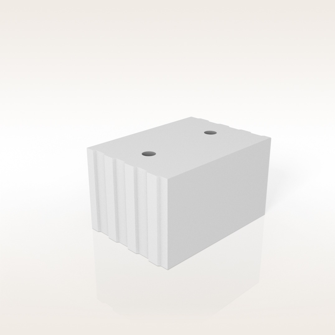 Bloczek wapienno-piaskowy Silka E24 na jasnym tle. Widoczne otwory i żłobienia. Minimalistyczna prezentacja produktu budowlanego.