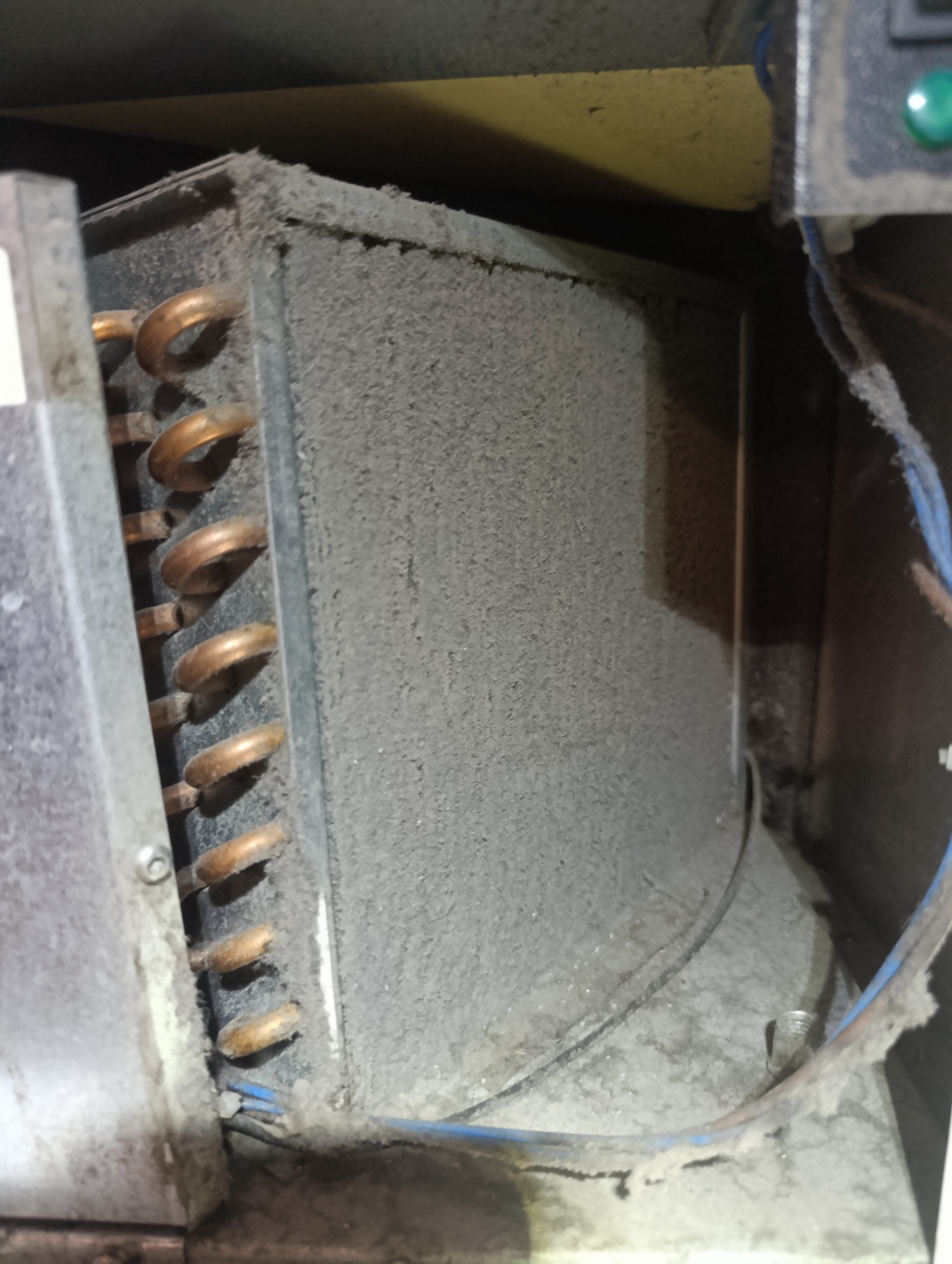 Zabrudzony, zakurzony wymiennik ciepła klimatyzacji z widocznymi miedzianymi rurkami i przewodami. Wymaga czyszczenia lub serwisu.