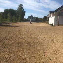 Usługi ogrodnicze Hubert Kurdziel - Przygotowany teren pod przyszły ogród w Lublinie. Dwóch mężczyzn podczas niwelacji terenu. W tle drzewa i budynki.