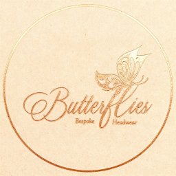 Grafico - Eleganckie logo 'Butterflies Bespoke Headwear' w odcieniach złota, z motywem motyla, umieszczone w okręgu na teksturowanym tle w kolorze beżowym.