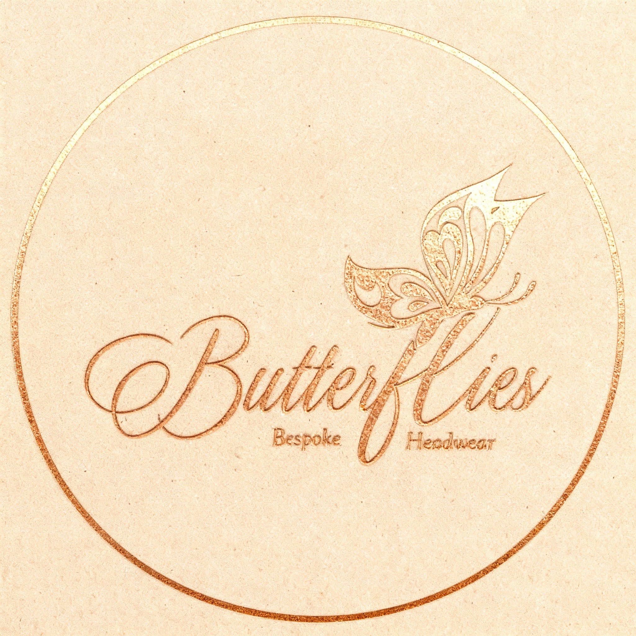 Eleganckie logo 'Butterflies Bespoke Headwear' w odcieniach złota, z motywem motyla, umieszczone w okręgu na teksturowanym tle w kolorze beżowym.