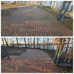 Michał Wiśniewski - Porównanie kostki brukowej przed i po czyszczeniu. Górna część z mchem i zabrudzeniami, dolna czysta, z widoczną kolorystyką. Metalowa brama w tle.