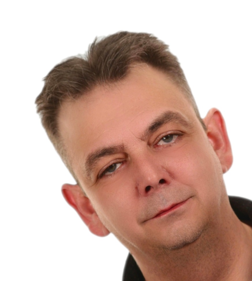 Portret mężczyzny z krótkimi włosami, lekko pochylona głowa, uśmiech na twarzy, na białym tle. Wyraz twarzy sugeruje pewność siebie i profesjonalizm.