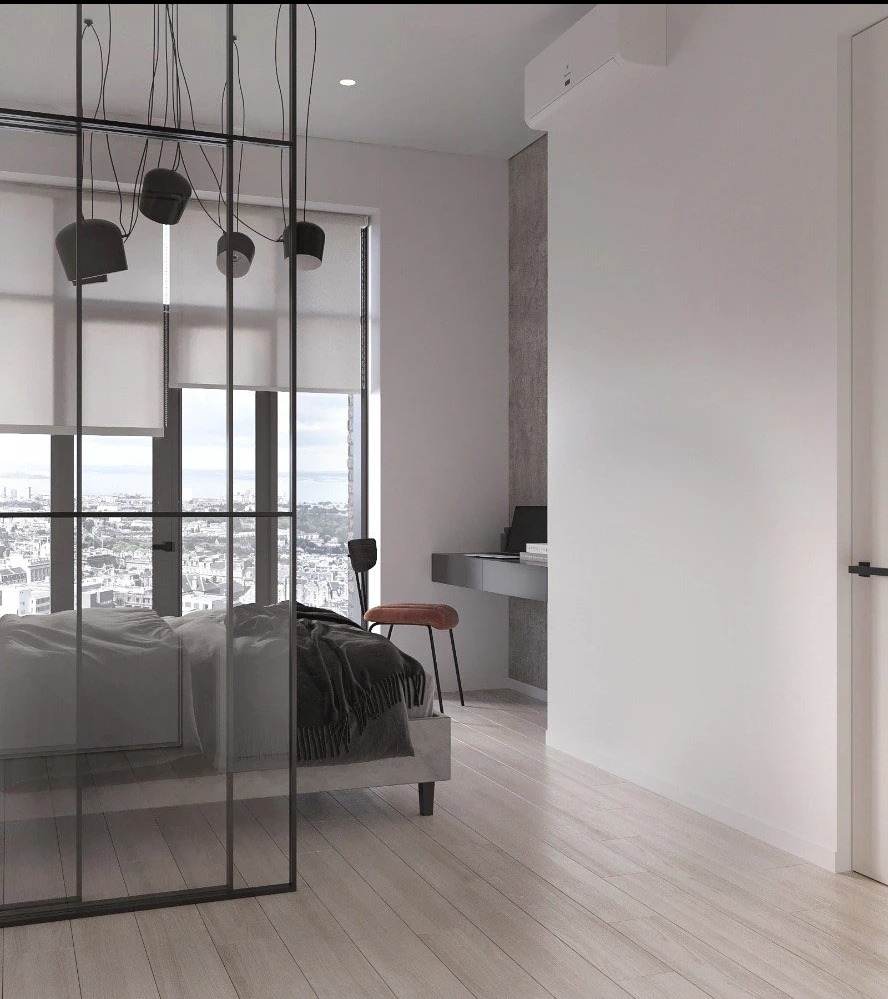 Minimalistyczna sypialnia z łóżkiem, szklaną ścianką działową i widokiem na miasto. Nowoczesne oświetlenie, biurko i krzesło w tle. Jasne drewniane podłogi.