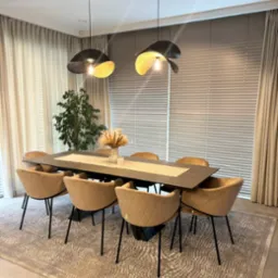 Eleganckie, poziome żaluzje aluminiowe w odcieniach beżu w nowoczesnym wnętrzu jadalni z designerskimi lampami i beżowymi krzesłami.