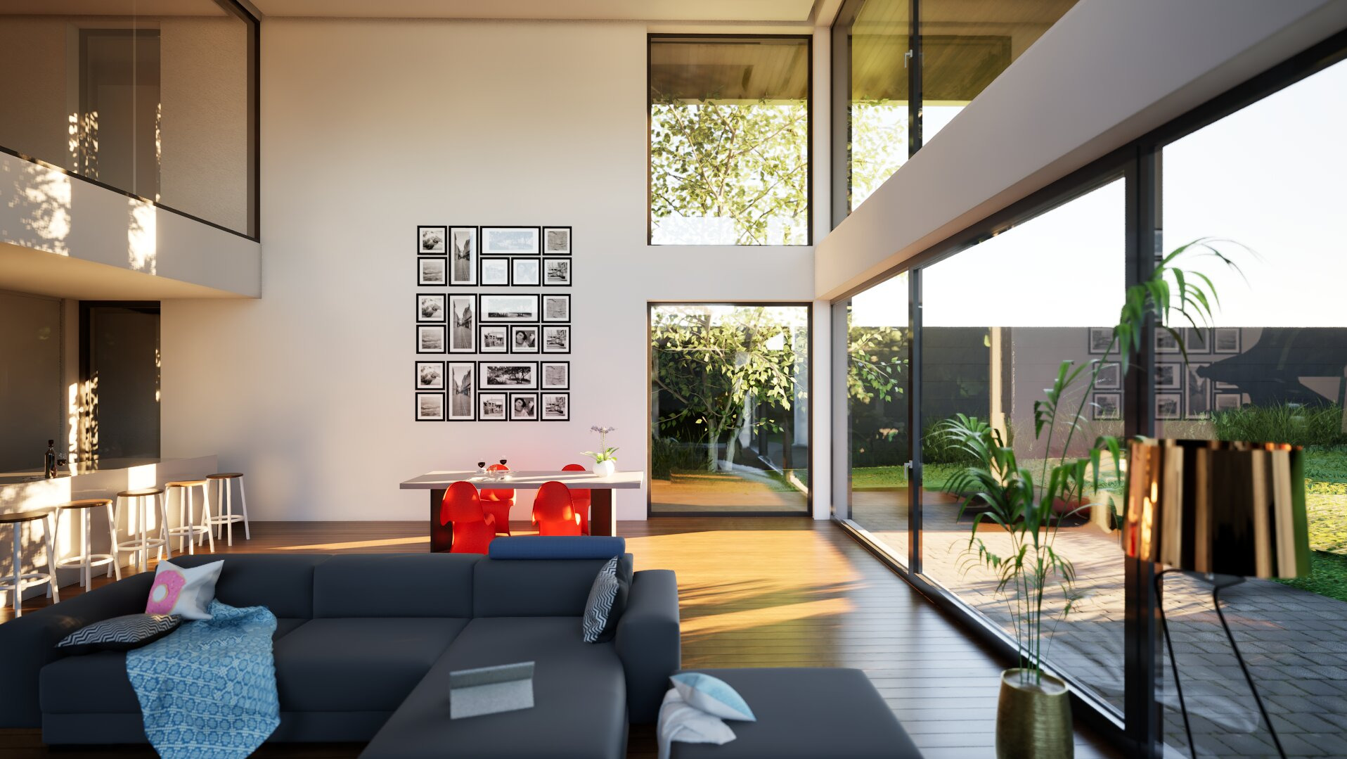 Nowoczesny salon z dużymi oknami, szarą sofą i drewnianą podłogą. Na ścianie galeria czarno-białych zdjęć. Widok na zielony ogród przez okna.