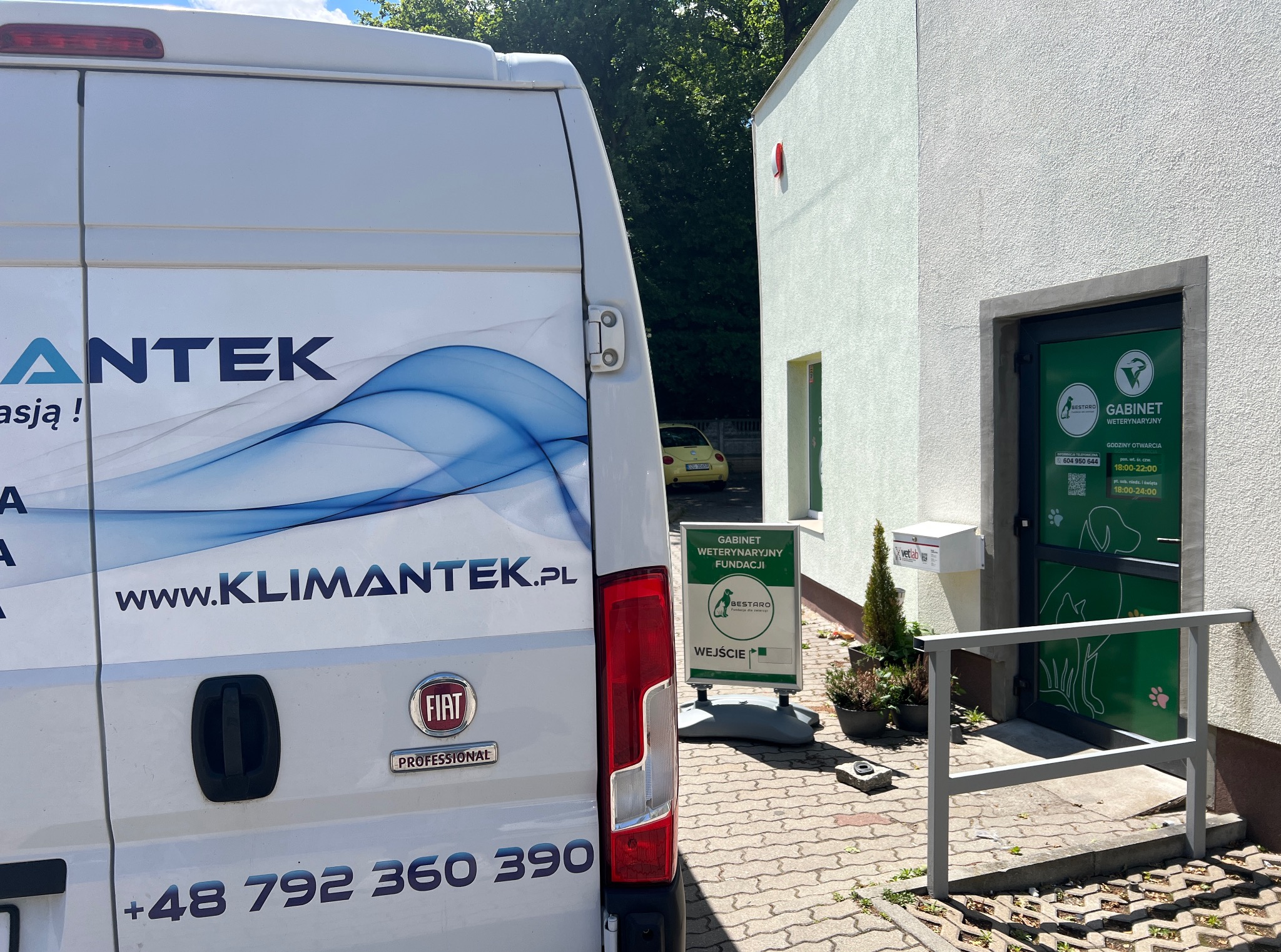 Samochód firmy Klimantek z numerem telefonu i adresem www na tle gabinetu weterynaryjnego Bestaro.