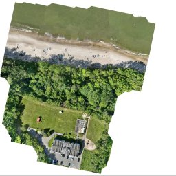L-PROJEKT USŁUGI PROJEKTOWE I INŻYNIERSKIE Paweł Lipski - Nietypowy widok z drona na budynek z parkingiem, przylegający do plaży z turystami i lasu. Ujęcie z góry, zniekształcone krawędzie kadru.