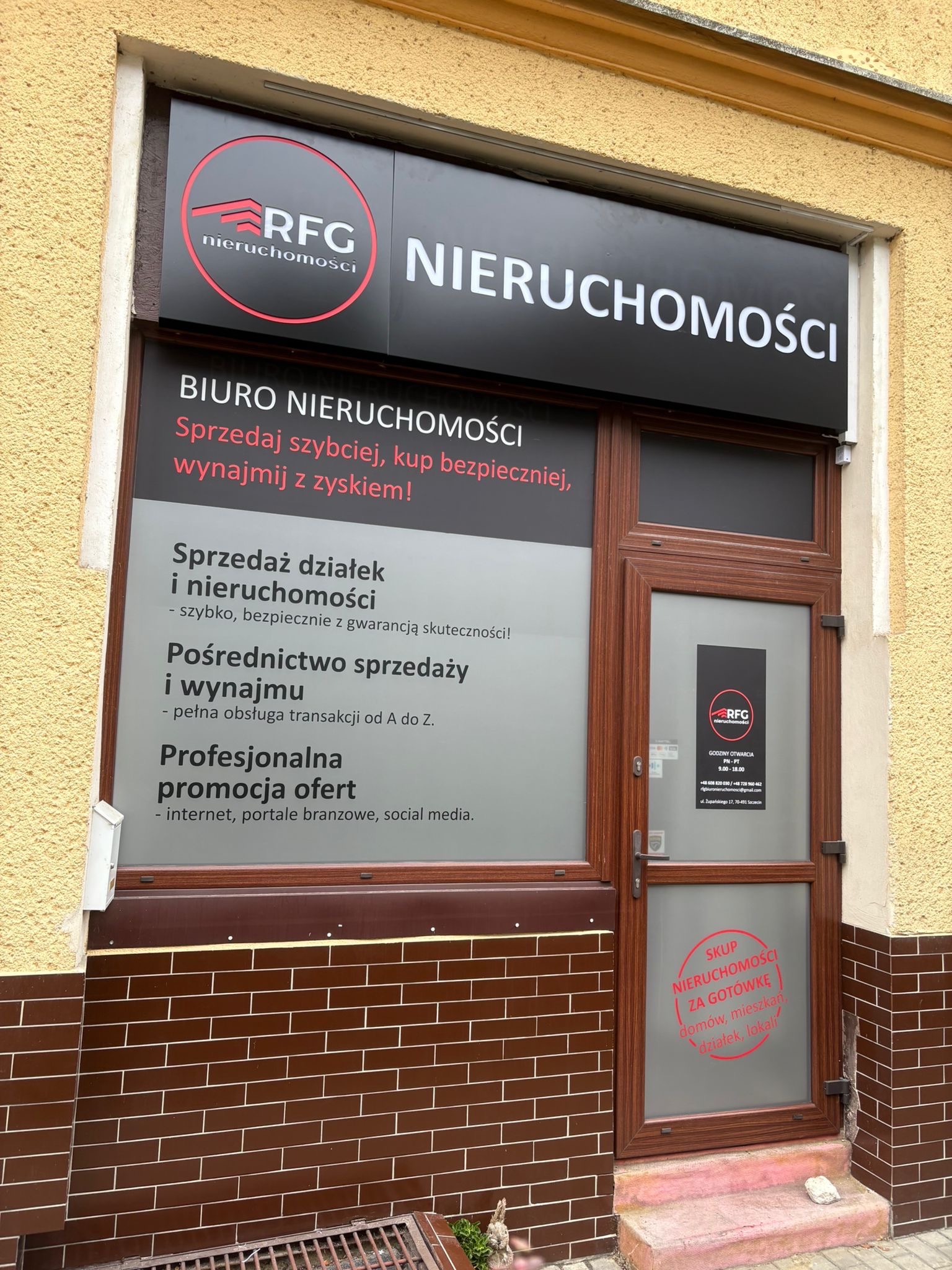 Fasada biura nieruchomości RFG w Szczecinie. Tablica z logo, okno z ofertami sprzedaży i wynajmu, naklejka 'Skup nieruchomości za gotówkę'.