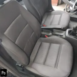 Wyczyszczone, szare fotele samochodowe z wyraźną strukturą materiału. Widoczny efekt po praniu tapicerki, wnętrze auta.