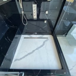 Soldatke Łazienki - Nowoczesna łazienka z kabiną typu walk-in, wykończona czarnym marmurem z białymi żyłami i białymi płytkami podłogowymi z szarym wzorem.