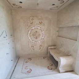 Soldatke Łazienki - Wykończona łazienka w beżowych tonacjach z dekoracyjnymi wzorami na ścianach, podłodze i suficie. Widoczne eleganckie zdobienia i wnęka w ścianie.