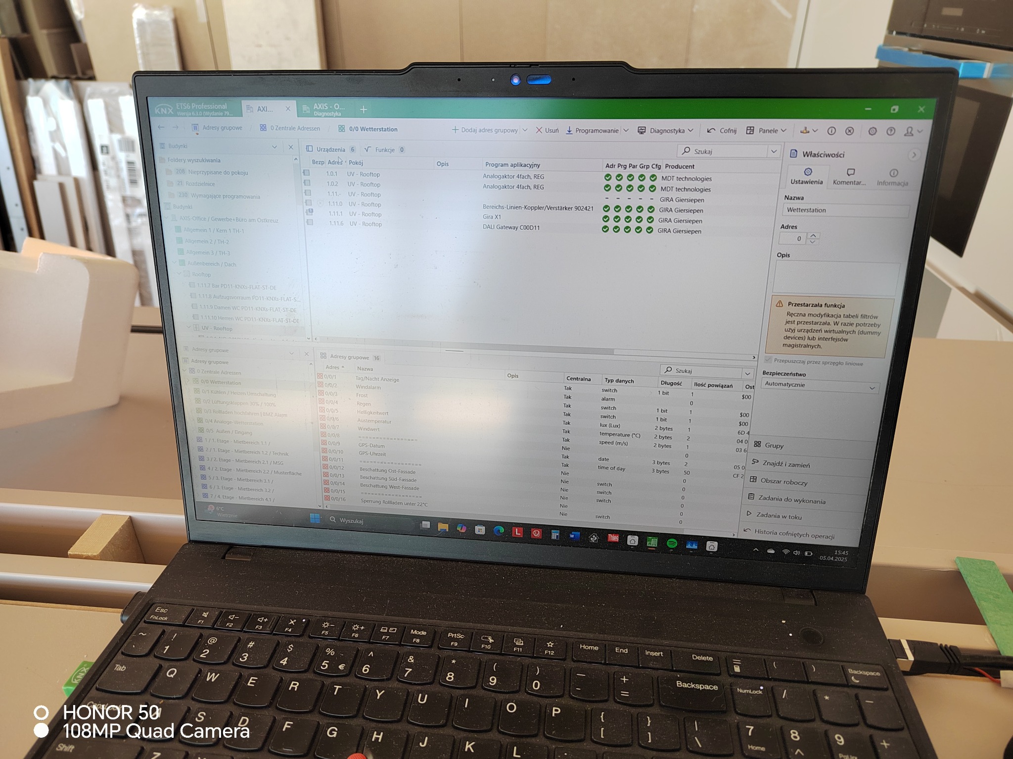 Laptop z otwartym programem ETS6 Professional, konfiguracja inteligentnego domu KNX. Widoczne okna z adresami grupowymi, urządzeniami i właściwościami.