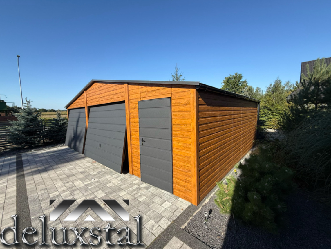 Nowoczesny garaż blaszany z dwiema bramami uchylnymi w kolorze szarym i dodatkowymi drzwiami, wykończony drewnopodobną blachą w ciepłym odcieniu brązu.