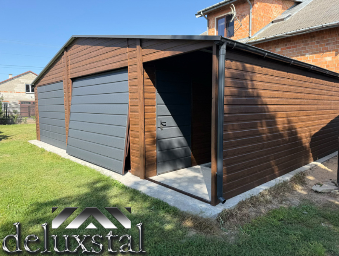 Dwustanowiskowy garaż blaszany w kolorze orzechowym z szarymi bramami uchylnymi i wiatą. Rynny odprowadzają wodę. Dodatkowe drzwi wejściowe. Widok z zewnątrz.