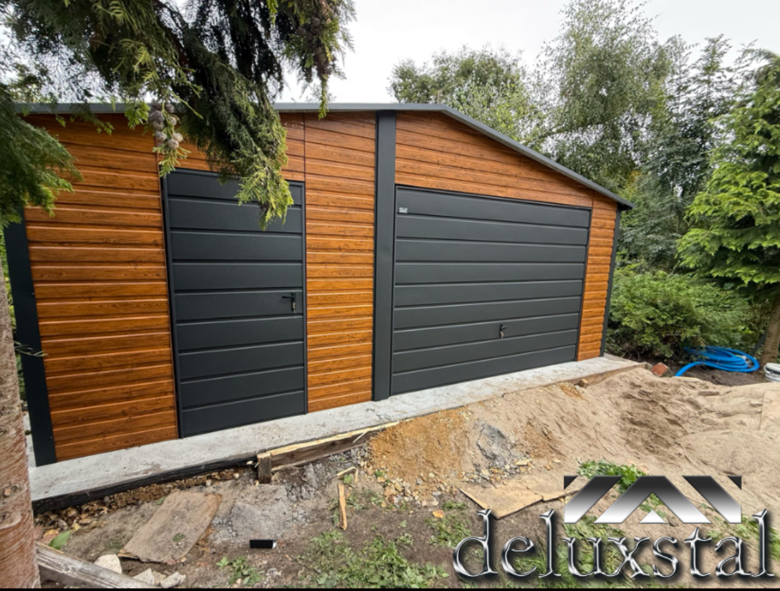 Nowoczesny garaż z blachy drewnopodobnej, z dwoma bramami w kolorze antracytowym, na betonowej wylewce, otoczony zielenią.