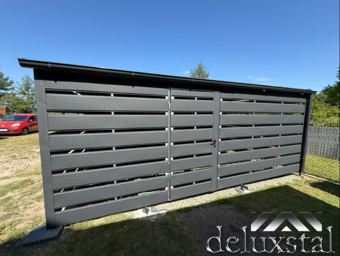 Nowoczesna, grafitowa konstrukcja z poziomych paneli, prawdopodobnie obudowa na śmietniki lub schowek narzędziowy, z widoczną furtką i elementami orynnowania.