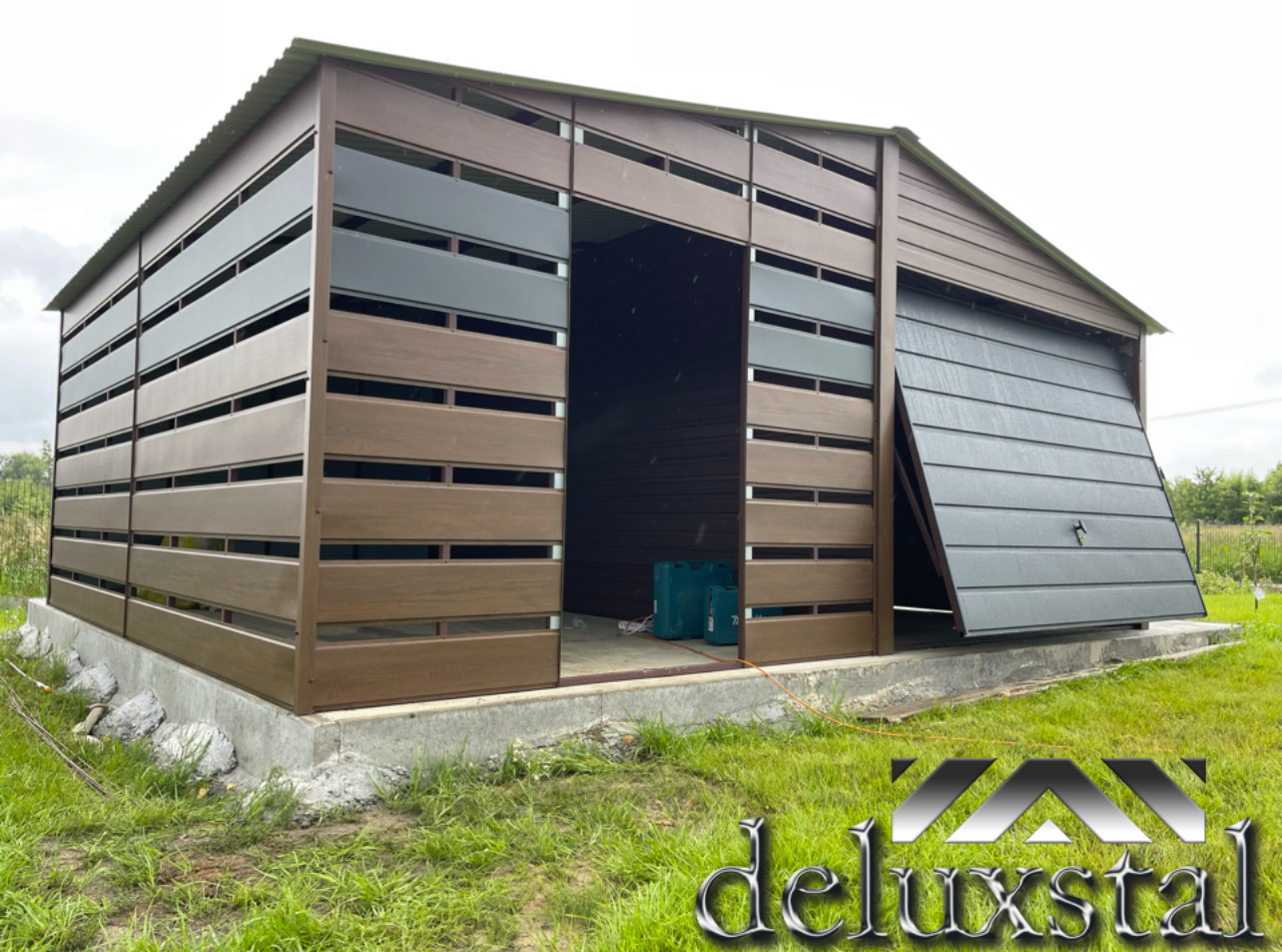 Nowoczesny garaż blaszany z poziomymi panelami w odcieniach brązu i szarości, z częściowo otwartą bramą segmentową i widocznymi kanistrami wewnątrz.