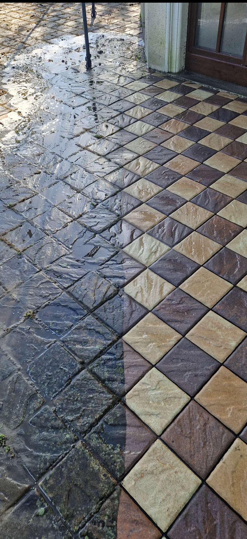 Kostka brukowa ułożona w szachownicę, w połowie umyta, prezentująca efekt przed i po czyszczeniu. Widoczne zabrudzenia i czysta powierzchnia.