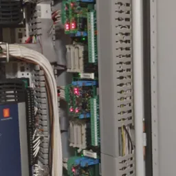 Panel sterowania z modułami TBSS1, TBSS2, TBSS3, TBSS4 P2, licznymi przewodami i elementami elektronicznymi w szarej obudowie. Widoczne diody sygnalizacyjne.