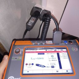 LOGOFORM Dariusz Dubrowski - Miernik MPI-540PV Sonel w trakcie pomiarów elektrycznych w gniazdku. Ekran urządzenia pokazuje wyniki pomiarów impedancji pętli zwarcia ZL-PE.