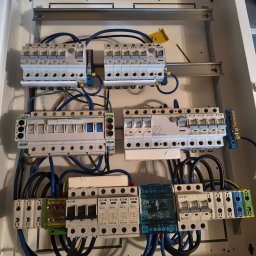 LOGOFORM Dariusz Dubrowski - Rozdzielnica elektryczna z zainstalowanymi bezpiecznikami i okablowaniem, widok z góry. Elementy Eaton i ETI. Instalacja w białej obudowie.