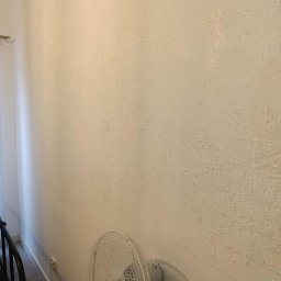 Czystonauta - Paweł Urbański - Zniszczona ściana z łuszczącą się farbą, widoczny wentylator. Usługi przygotowania ścian do malowania w Krakowie. Remont pokoju przed odświeżeniem.