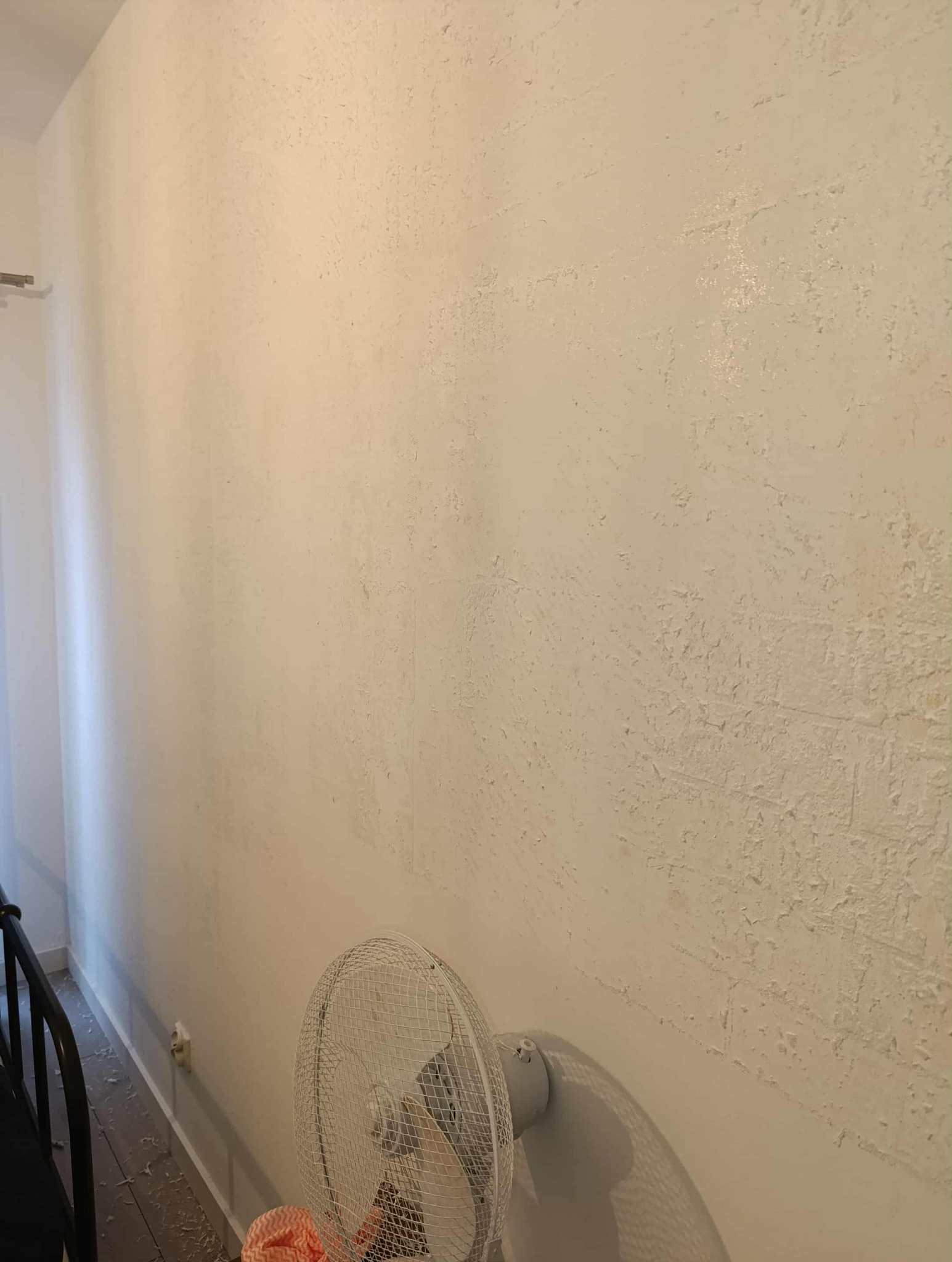 Zniszczona ściana z łuszczącą się farbą, widoczny wentylator. Usługi przygotowania ścian do malowania w Krakowie. Remont pokoju przed odświeżeniem.